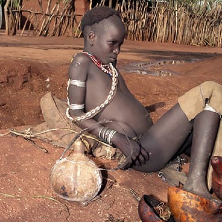 Chase | Ethiopia - 153-14 Hammar teenager with shaved head resting at Demeka