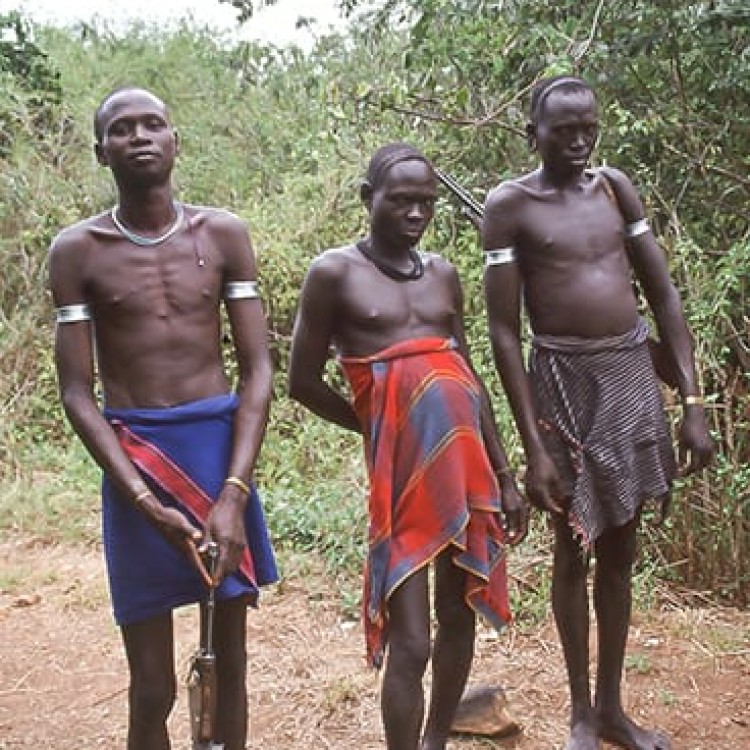 Chase | Ethiopia - 165-18s Mursi men in loincloths blocking path with AK47s